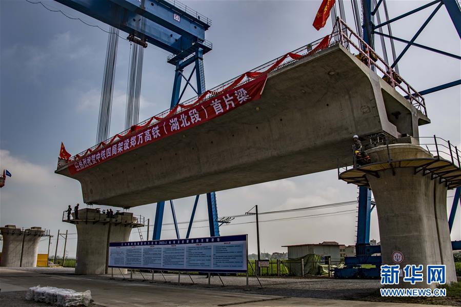 7月10日，中铁四局工作人员在湖北省襄阳市襄州区境内的郑万铁路白河特大桥架梁。　　近年来，中国高铁继续保持快速发展步伐，“四纵四横”高铁网基本成形，技术成就赢得国际声誉，服务品质不断攀升。中国高铁已经成为一张见证时代发展的名片。新华社记者 杜华举 摄