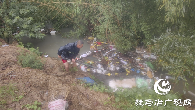 驻马店经济开发区贾庄居委会志愿者冒雨清理河道